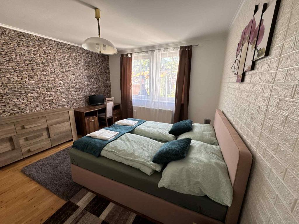 a bedroom with a bed with blue pillows on it at Park apartman Kertes ház a park mellett gyönyörű kilátással Dog friendly garden house with a wonderful view next to the park in Murau