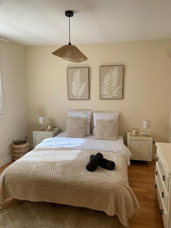 a bedroom with a bed with a hat on it at Maison cosy avec cour privée - Calme et nature, La Trimouille in La Trimouille