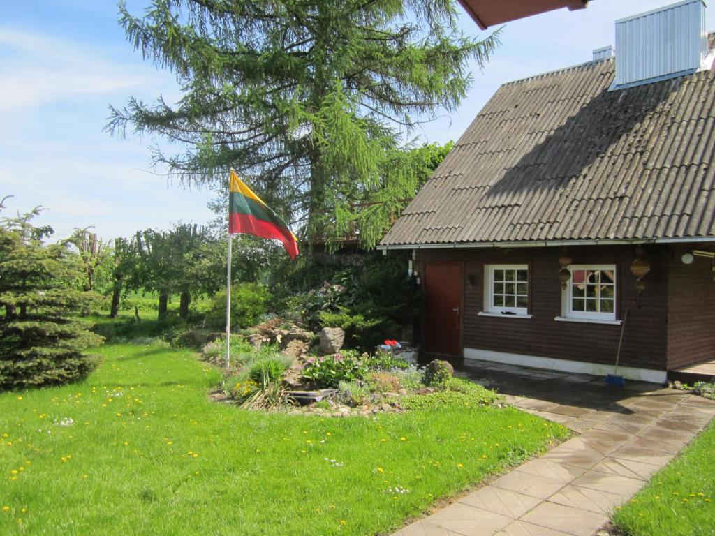 a flag in a yard next to a house at Prienų vienkiemis in Kelmė