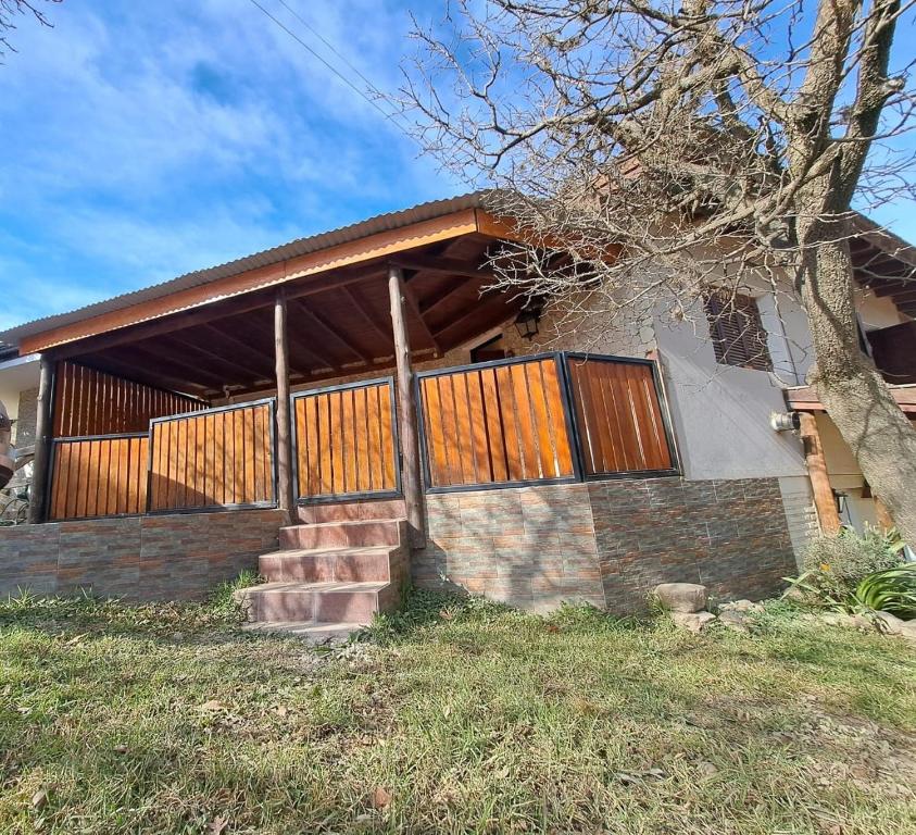 a house with wooden doors and stairs in front of it at Rincon de Golu - Villa General Belgrano in Villa General Belgrano