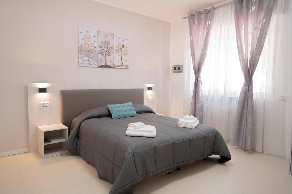 a bedroom with a bed with two towels on it at Carrera Living Family Apartments in Borgomanero