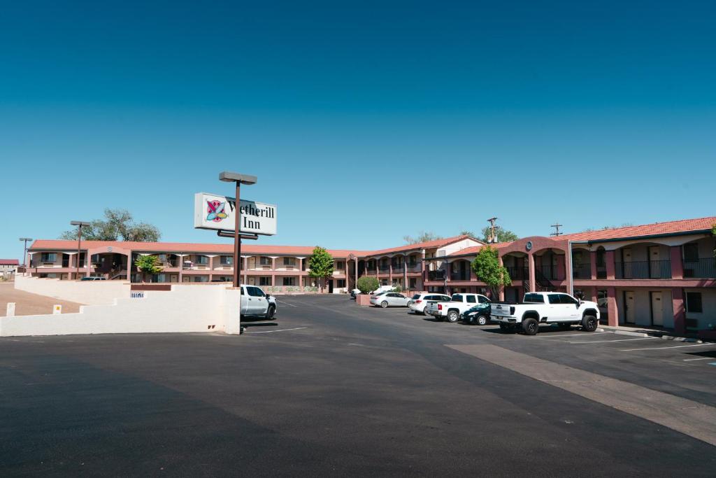Un estacionamiento con autos estacionados frente a un motel. en Wetherill Inn, en Kayenta