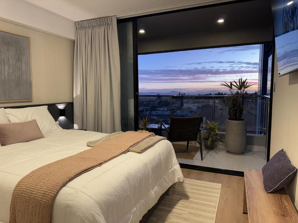 a bedroom with a bed and a large window at Luxury Tower Top Floor Apartment 