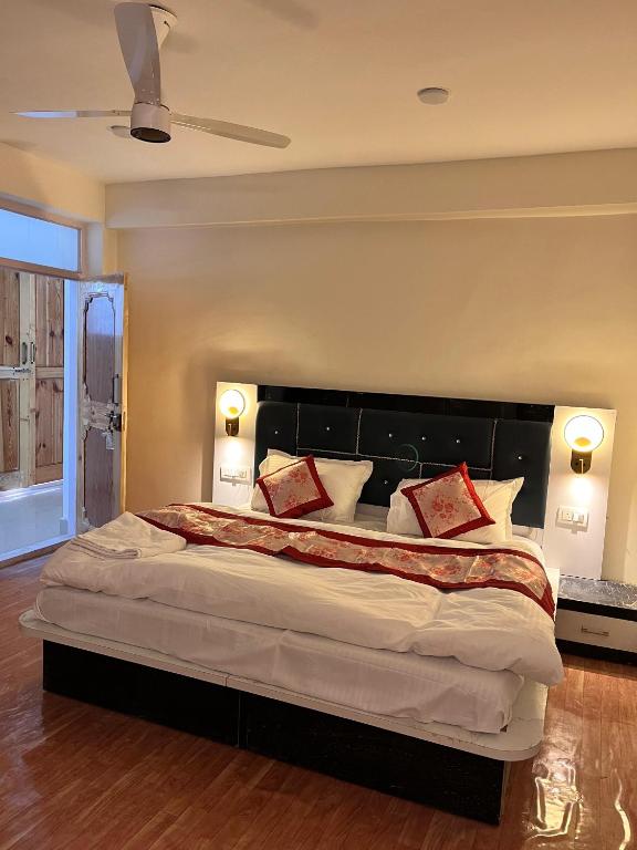 a bedroom with a large bed with red pillows at Hotel The Kargil Castle in Kargil