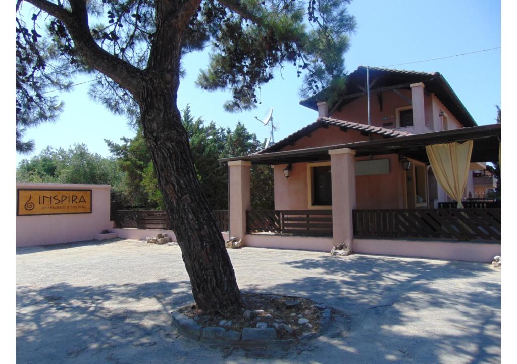 a house with a tree in front of it at INSPIRA THASSOS APARTMENTS and STUDIOS in Skala Sotiros