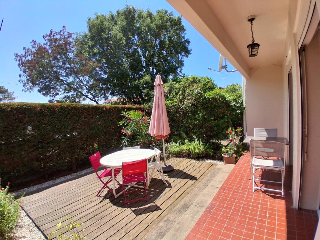 a table and chairs and an umbrella on a patio at T3 à Vieux-Boucau-Les-Bains - quartier calme entre commodités et plages - FR-1-239-1134 in Vieux-Boucau-les-Bains