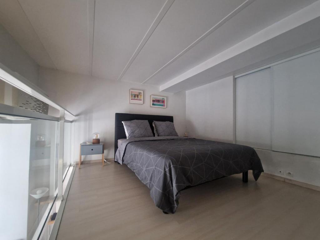 una camera da letto con un letto in una stanza bianca di Carré d'Or Star Loft a Nizza