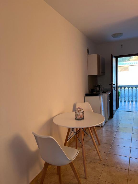 a kitchen with a table and chairs in a room at Apartmani Gazivode in Budva