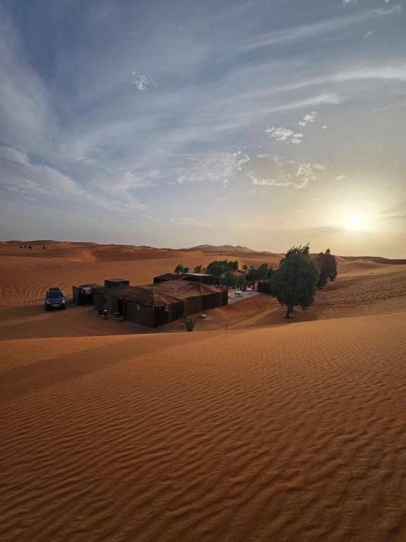 a building in the middle of a desert at Mustapha Camp Merzouga in Merzouga