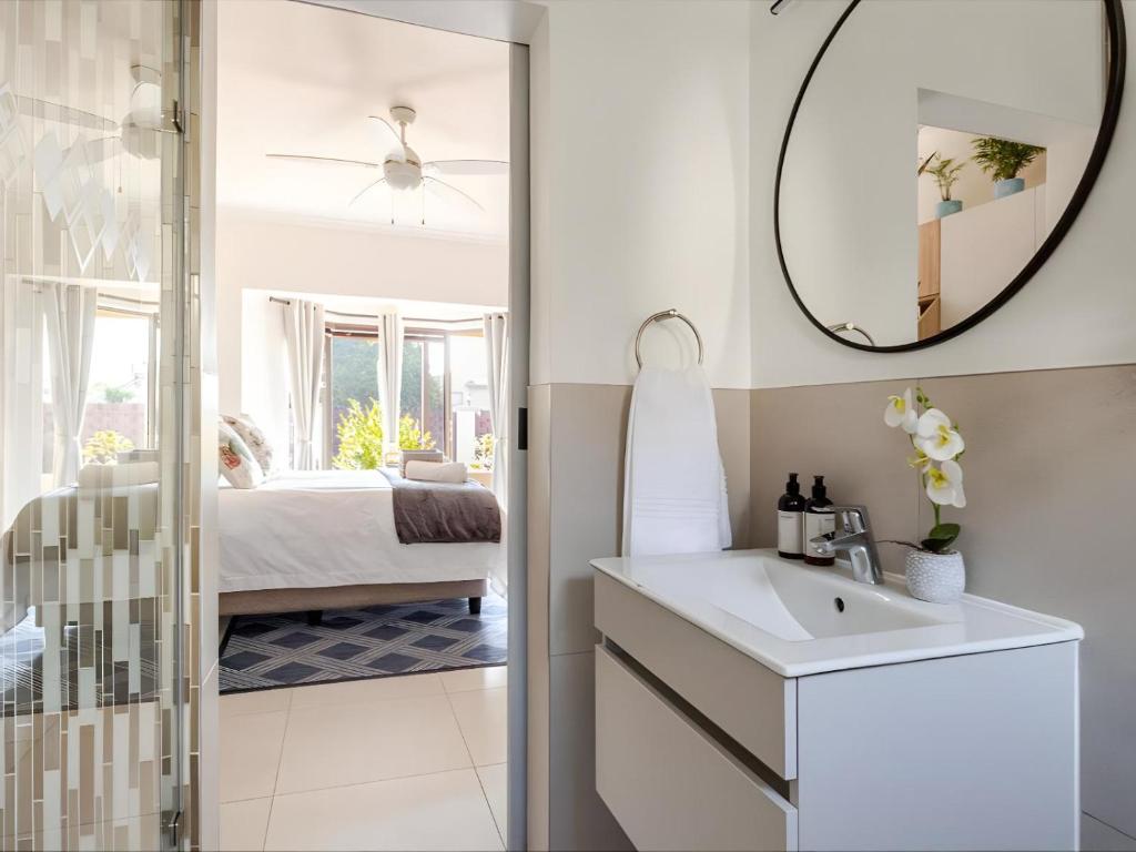 a bathroom with a sink and a mirror at Amalfi Place in Pretoria
