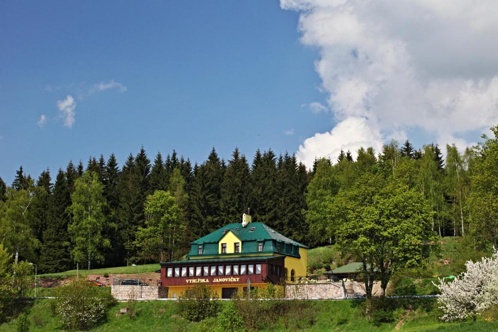 een huis op een heuvel met bomen op de achtergrond bij Penzion Vyhlídka Janovičky in Broumov