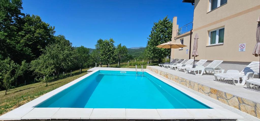 a swimming pool with chairs and a building at Villa Green Oasis Swimming pool in SJJ