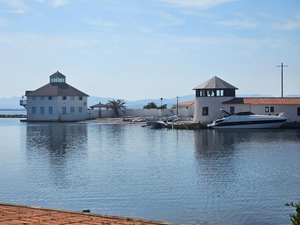 - deux bâtiments avec des bateaux dans l'eau dans l'établissement Pétanque at 52 air conditioning, au Barcarès