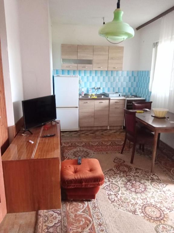 a living room with a table and a kitchen at Braco apartmani Utjeha in Kravlja
