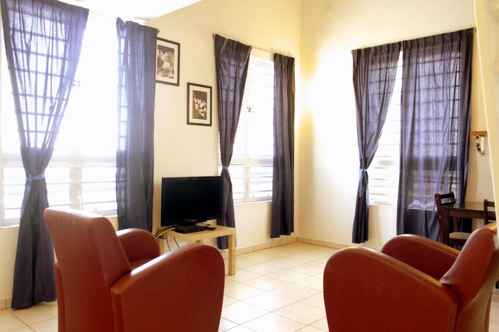 TV a/nebo společenská místnost v ubytování Orange Rembrandt Studio Apartments