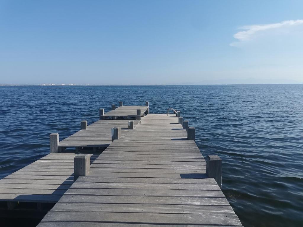 une jetée en bois au milieu de l'eau dans l'établissement Le Cardinale in Barcarès Beach 4 people, au Barcarès