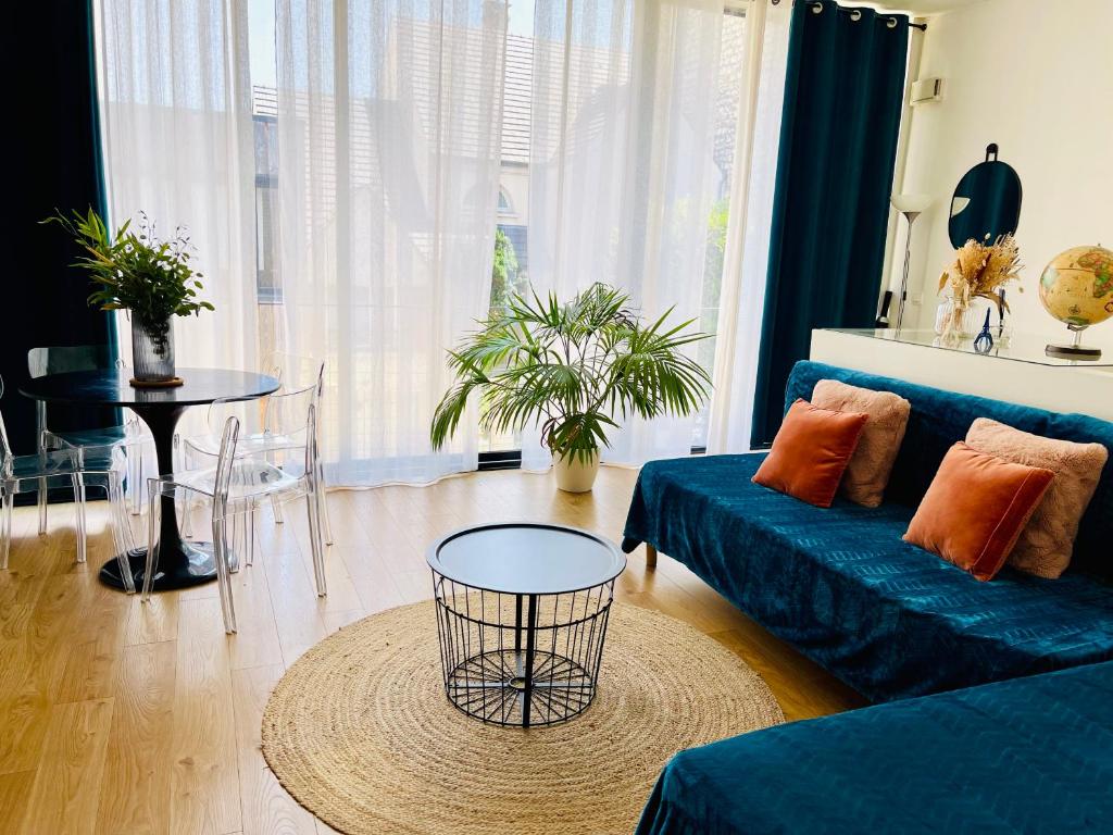 un salon avec un canapé bleu et une table dans l'établissement Maison 50 m2, à 5 minutes de Paris et idéal pour Disney, à Montreuil