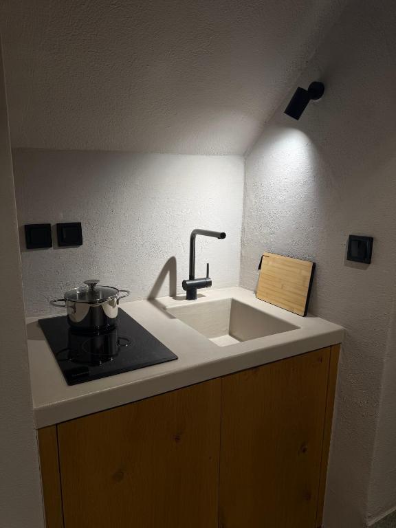a kitchen sink with a pot on a stove at EJ Boutique Suites in Milina