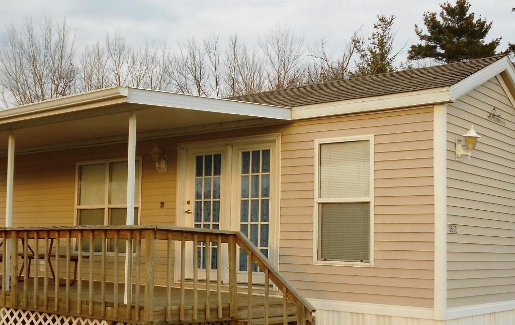 una casa con portico e terrazza di O'Connell's RV Campground Park Model 34 a Inlet