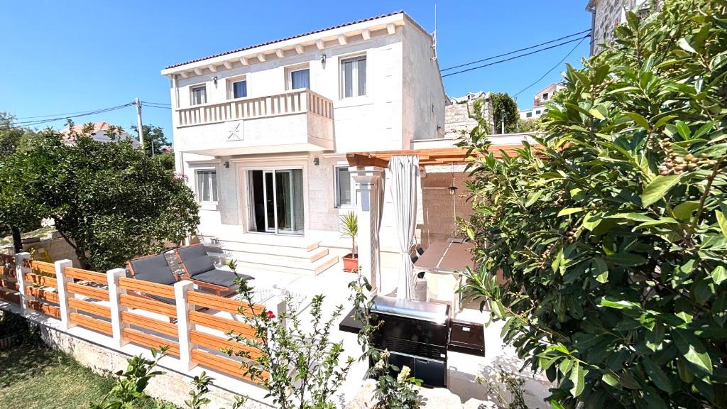a white house with a wooden fence in front of it at BUKY HOUSE in Sumartin