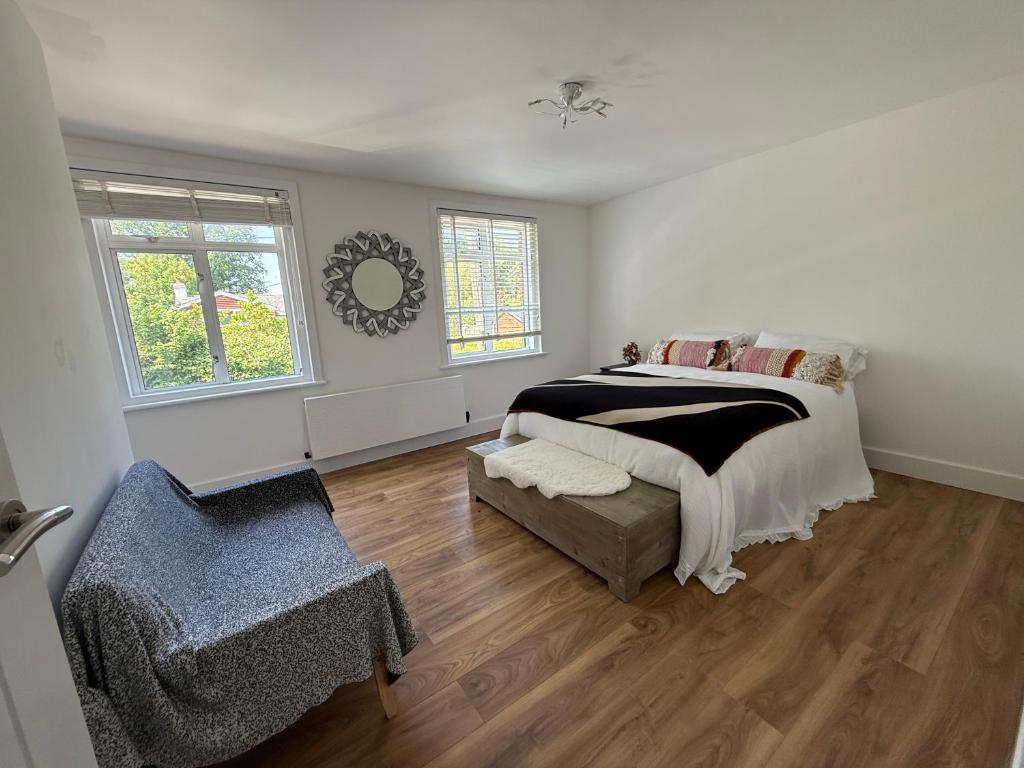 a bedroom with a bed and a chair in it at Spacious 4-Bedroom Home in Liss