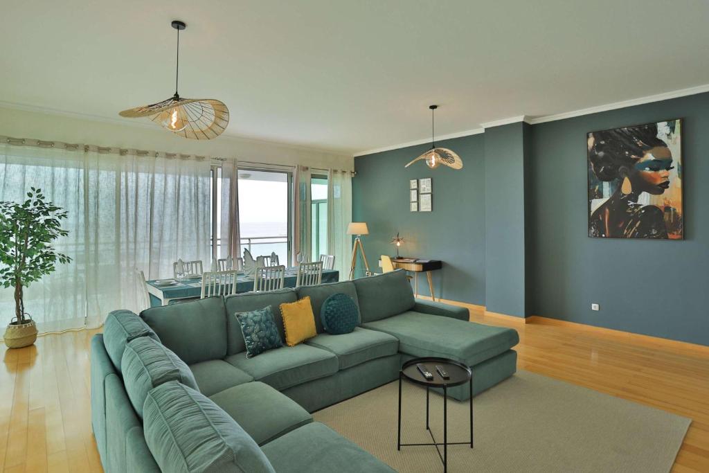 a living room with a green couch and a dining room at The Panoramic View Suites in Machico