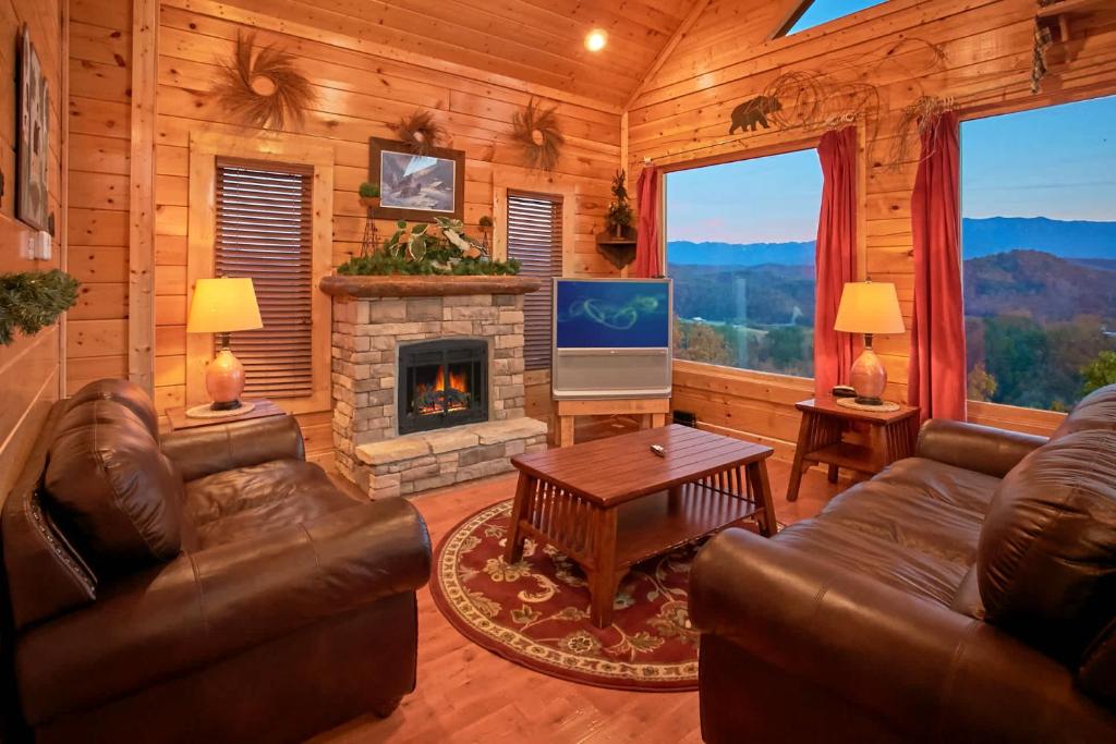 Una sala de estar con muebles de cuero y chimenea. en Cozy Getaway w View Pool Table Arcade & Hot tub, en Sevierville