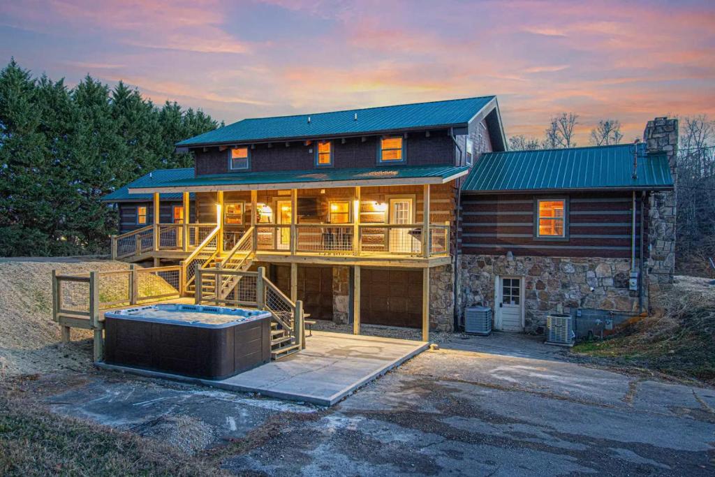 a large house with a deck and a hot tub at Smokies Getaway with Fire Pit Game Room & Hot Tub in Pigeon Forge