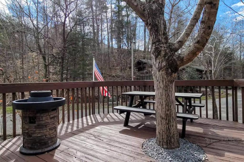 una mesa de picnic junto a un árbol en una terraza de madera en Smoky Mountain Retreat with Game Room Firepit, en Sevierville