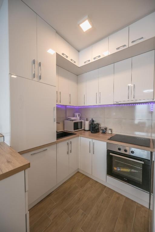 a white kitchen with white cabinets and appliances at Apartman TRI KRALJA 1 in Banja Koviljača