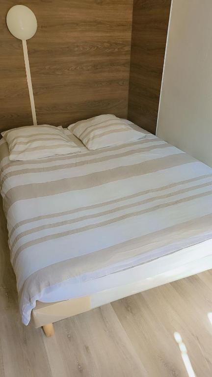 - un lit avec des draps blancs et une lampe dans l'établissement Hôtel des 2 Gares, à Nevers