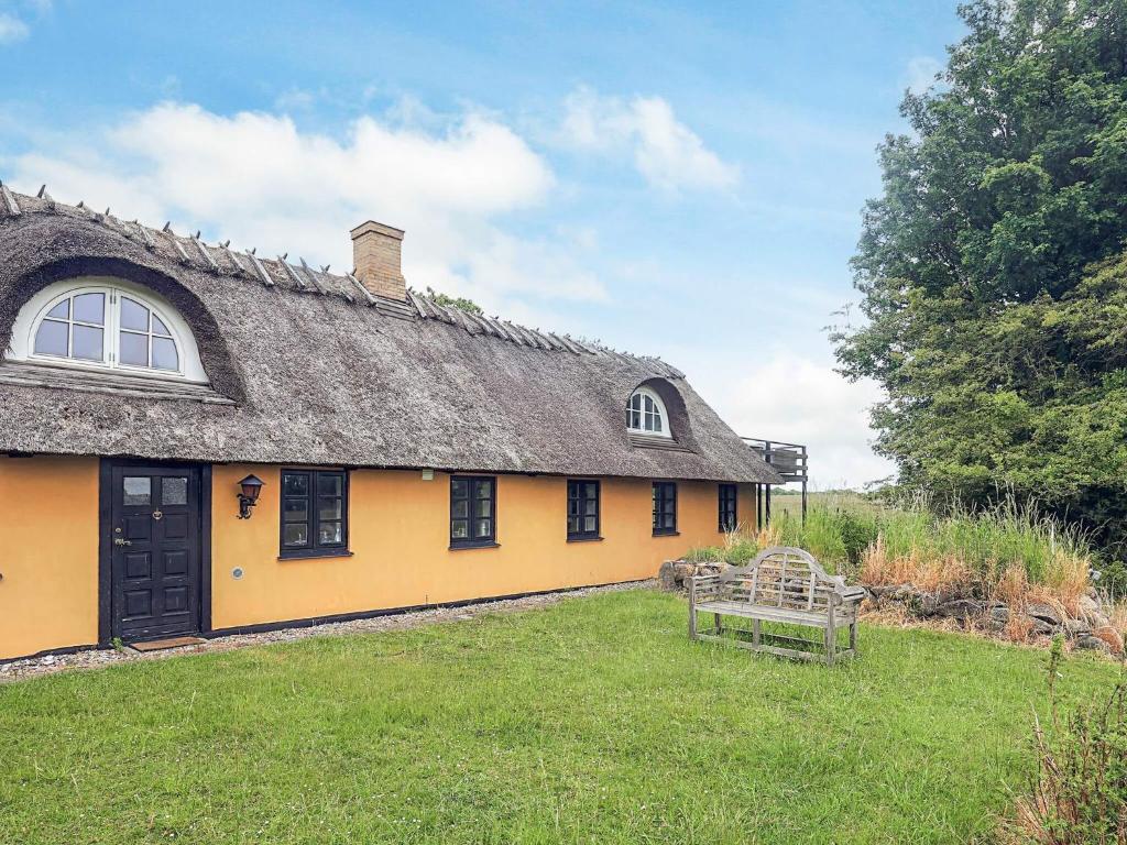 een groot geel huis met een rieten dak bij 6 person holiday home in Rudkøbing in Rudkøbing
