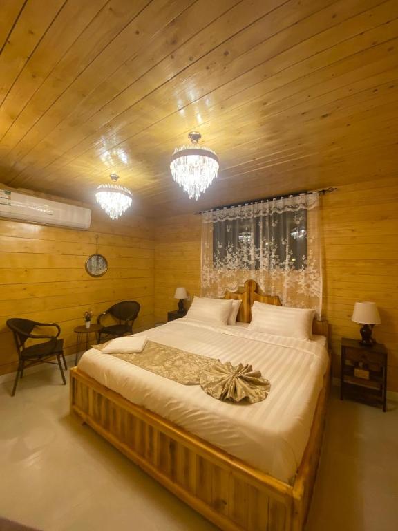 a bedroom with a large bed with wooden walls at كوخ خزامى الباحة in Al Baha