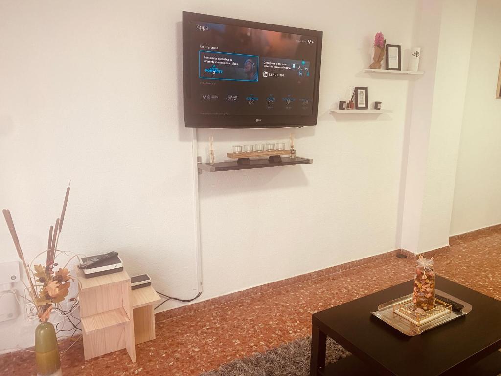 a living room with a flat screen tv on the wall at Cataleya Apartment in Cullera