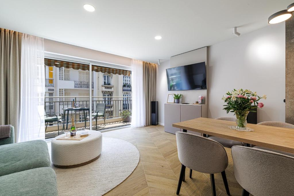 un salon avec une table et des chaises et une salle à manger dans l'établissement Sun, Style and Comfort - 2BR in Nice Center with Terrace & Garage, à Nice