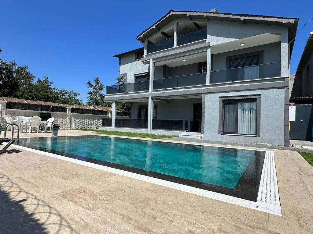 a house with a swimming pool in front of a house at Lux Villa Silivri Kavakli in Silivri