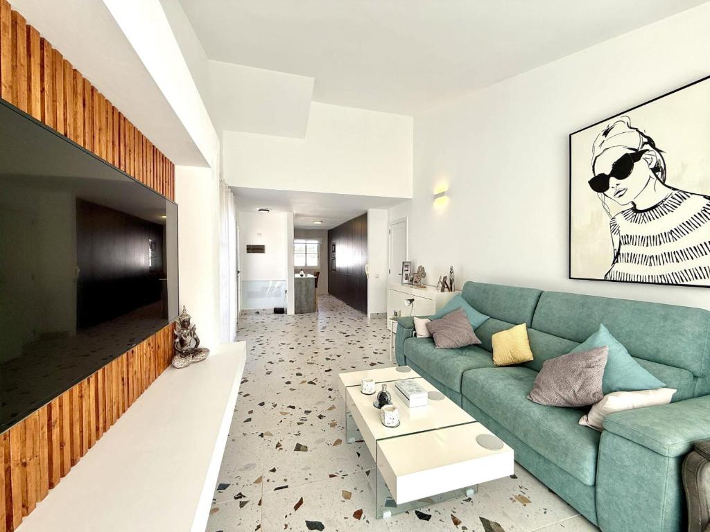a living room with a green couch and a table at Villa Stay & Enjoy in Antigua