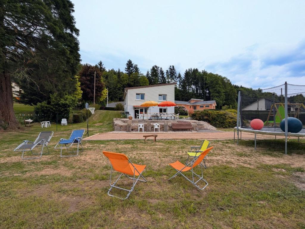 un groupe de chaises assises dans l'herbe dans l'établissement Maison spacieuse avec SPA, nature & calme dans les Vosges - FR-1-589-757, à Fraize
