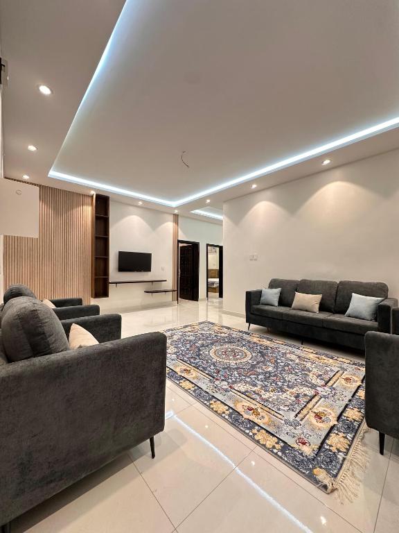 a living room with two couches and a rug at شقق اطلالة الضباب الباحه in Al Baha