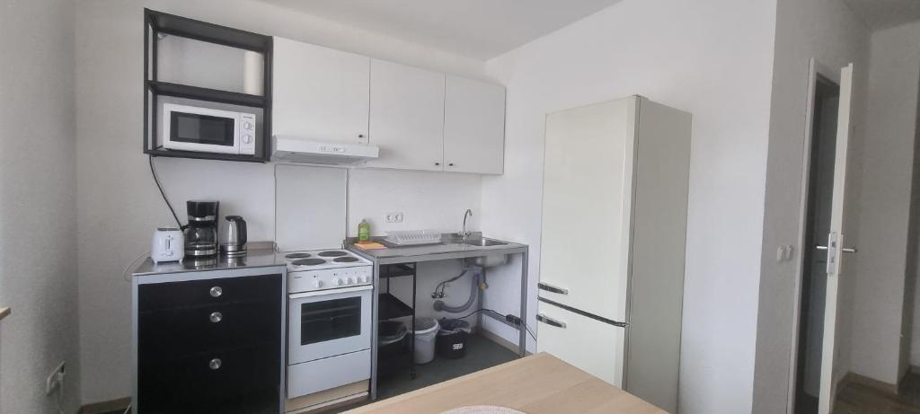 een kleine keuken met een fornuis en een magnetron bij Arzberger Monteurapartment in Arzberg