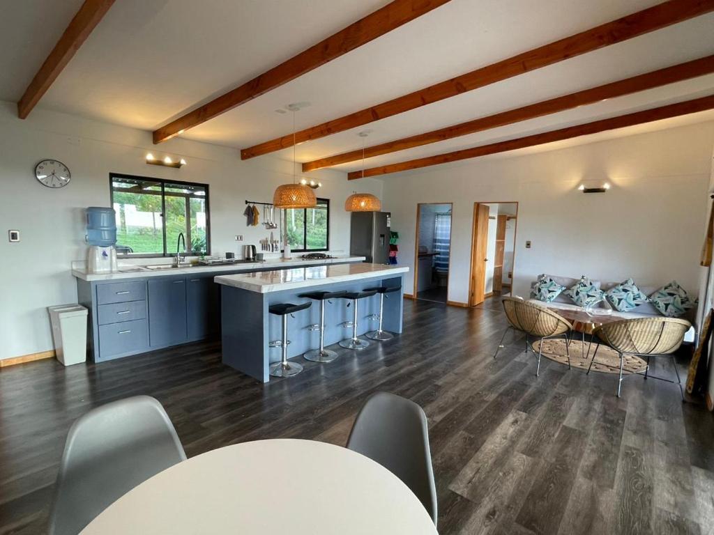 a large kitchen with a table and a couch at Tama House in Hanga Roa