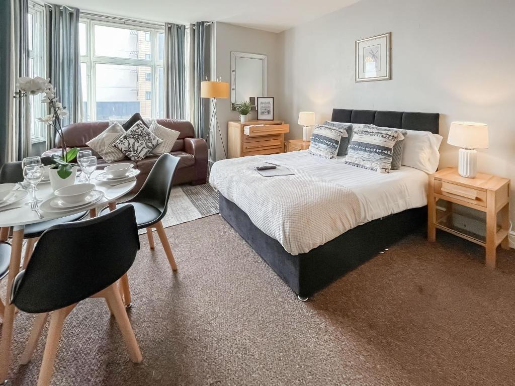 a bedroom with a bed and a table and a couch at Pier View Apartment 2 - Uk48502 in Skegness