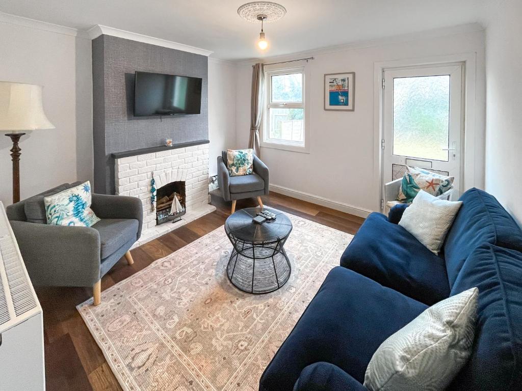 a living room with a blue couch and a fireplace at Beach Oasis Cottage - Uk48530 in Margate