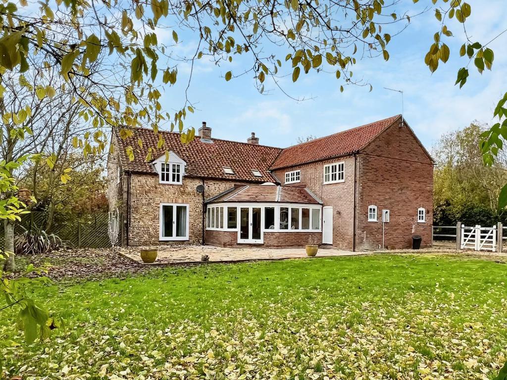 ein Bild eines Backsteinhauses mit einem Hof in der Unterkunft Sandy Toes Cottage in Beechamwell