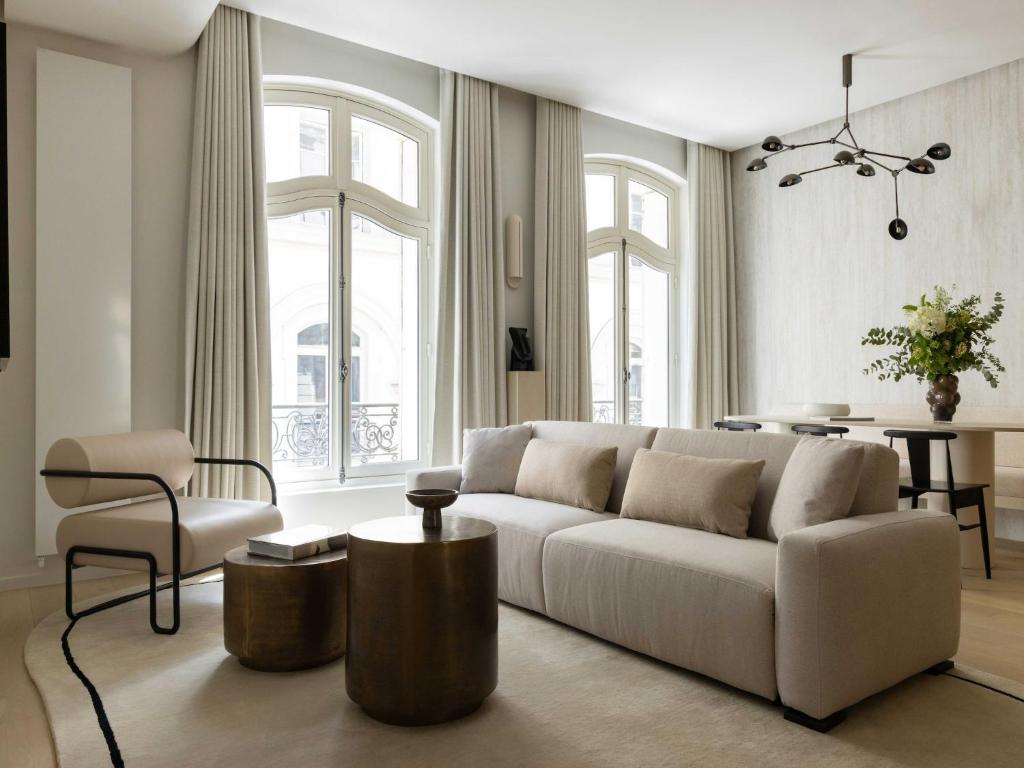 un salon avec un canapé blanc et une table dans l'établissement Luxury flat -2BR 6P- Madeleine Saint Honore, à Paris