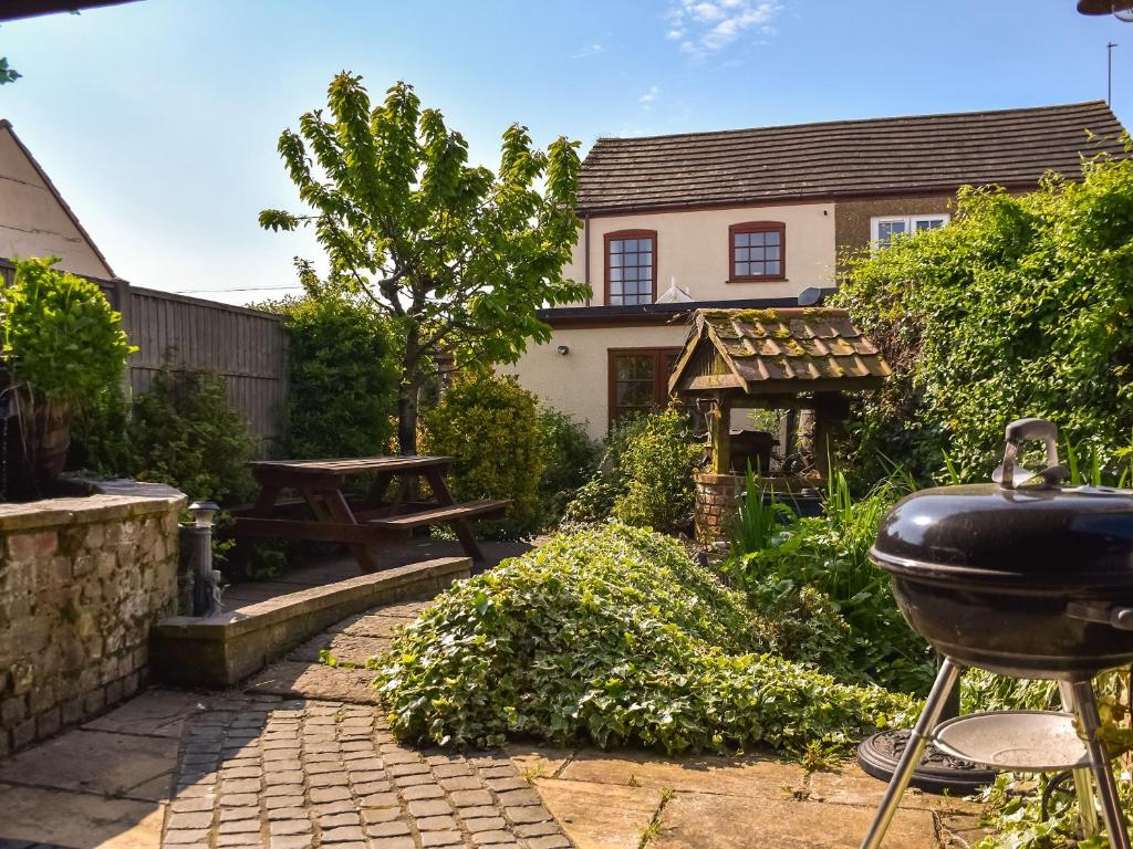 a backyard with a grill and a picnic table at Honeysuckle Cottage in Great Yarmouth