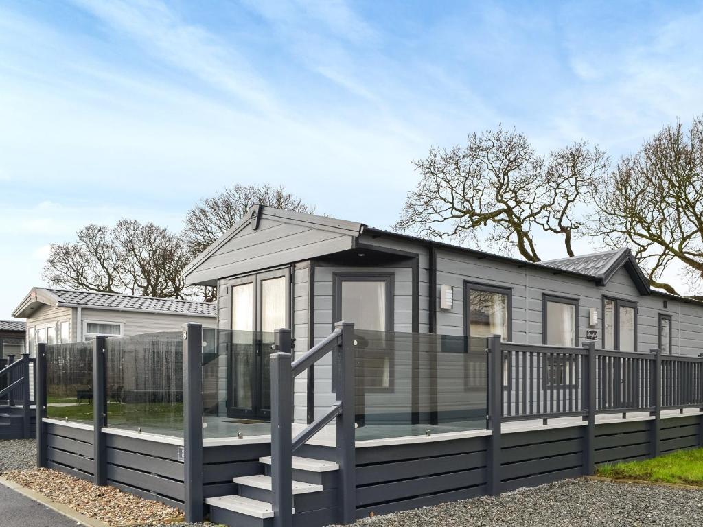 a tiny house with a porch and a fence at Rosie's Retreat - Uk46724 in Bridlington