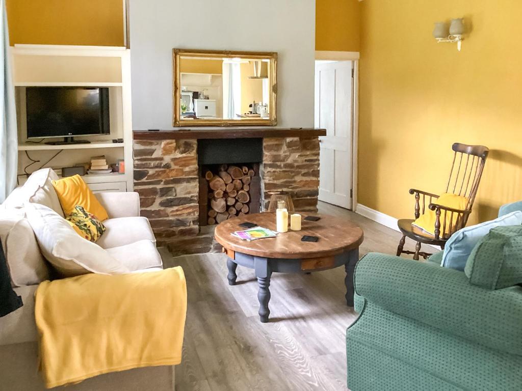 ein Wohnzimmer mit Tisch und Kamin in der Unterkunft The Old Bakehouse in Perranporth