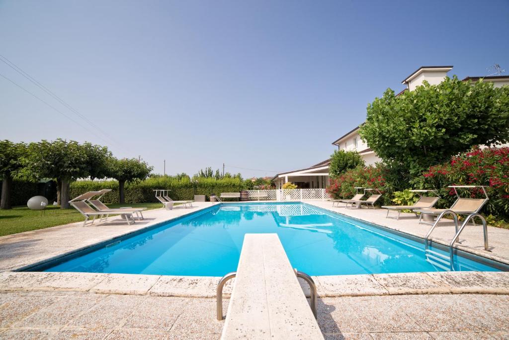 een zwembad met ligstoelen en stoelen eromheen bij Hotel Country House La Radice in Civitanova Marche