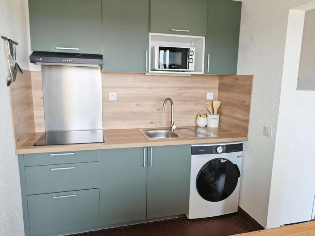 une cuisine avec un évier et une machine à laver dans l'établissement Appartement climatisé avec terrasse, parking privatif à Le Barcarès - FR-1-195-122, au Barcarès